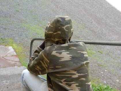 huppupäinen nuori istuu selin kameraan