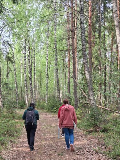 Kolme ihmistä kävelemässä luontopolulla.