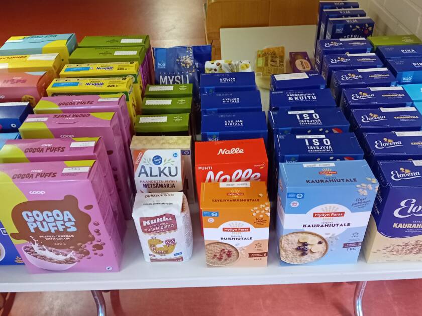 Kuvassa on pöydällä useita puurohiutalepakkauksia ja muropakkauksia.