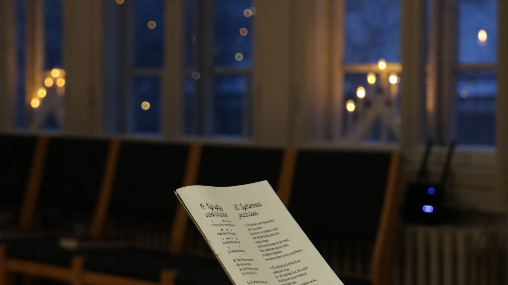 Kuvassa ikkunalla joulun kyntteliköt ja joululauluvihko